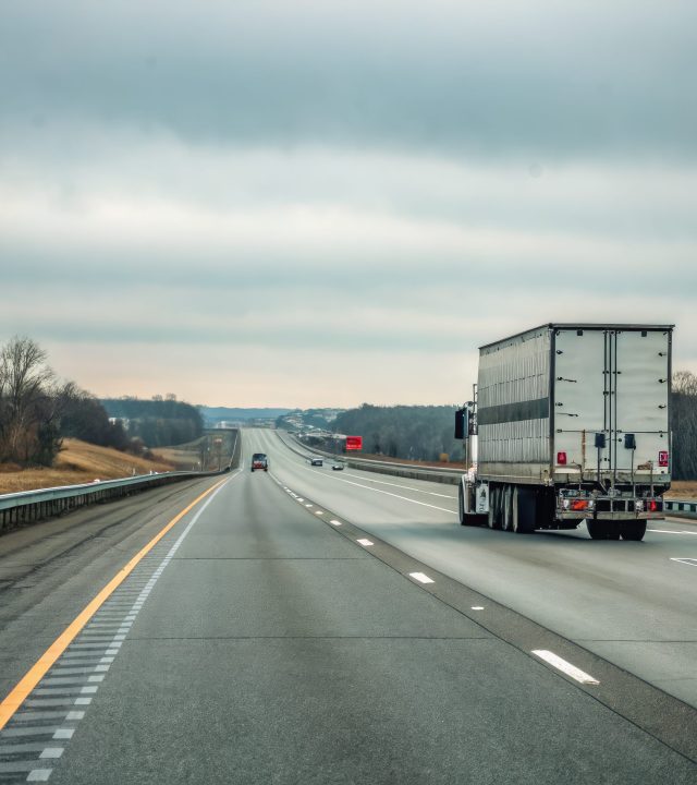 truck traveling down interstate overcast skies early morning light generative ai